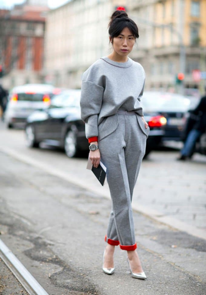 femme brune portant un ensemble en molleton jogging gris et rouge avec des chaussures à talons